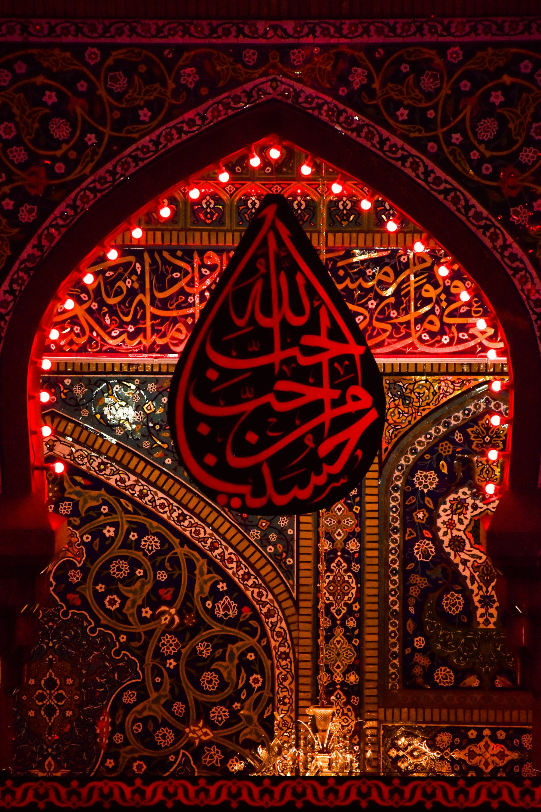 Red-lit shrine detail with devotional alam